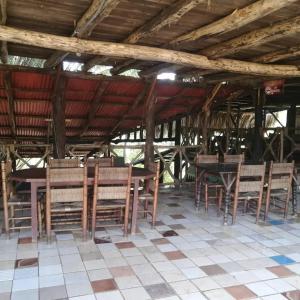 un grupo de mesas y sillas bajo un techo en Rancho paola nature, en Cotuí
