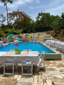 una mesa y sillas frente a una piscina en Rancho paola nature, en Cotuí