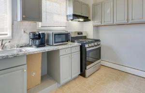 a kitchen with white cabinets and a stove top oven at Cozy bedroom 6 minutes from Newark Liberty International Airport Rm C in Newark