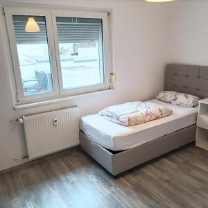 een kleine slaapkamer met een bed en 2 ramen bij Hattersheim 3 Room Apartment in Hattersheim