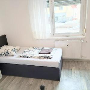 een klein bed in een kamer met een raam bij Hattersheim 3 Room Apartment in Hattersheim