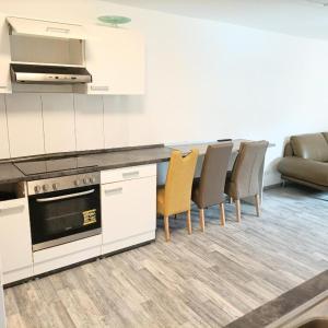 een keuken met witte kasten en stoelen en een bank bij Hattersheim 3 Room Apartment in Hattersheim