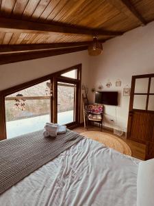 a bedroom with a bed with a large window at Haremi Garden Suit Bungalovs 