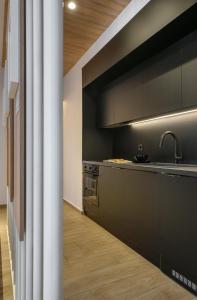 a kitchen with black cabinets and a sink at Heritage & Tales: Sihna in Litochoro