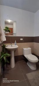La salle de bains est pourvue de toilettes blanches et d'un lavabo. dans l'établissement HOSPEDAJE TURISTICO CHORRILLOS Sueños de Luna INN, à Lima