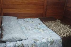 a bed with a blanket and pillows on it at Casa de campo na cidade in São José