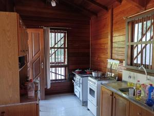 a kitchen with wooden walls and a stove top oven at Casa de campo na cidade in São José +5 photos