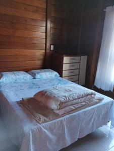 - une chambre avec un grand lit et un mur en bois dans l'établissement Casa de campo na cidade, à São José