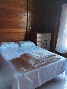 a bedroom with a large bed with a wooden wall at Casa de campo na cidade in São José
