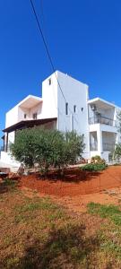 un edificio blanco frente a un campo de tierra roja en Casa Lazareta, en La Canea