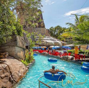 a man in a raft in a pool at a resort at Spazzio diRoma RM Hospedagem com Acesso Acqua Park/Splash in Caldas Novas