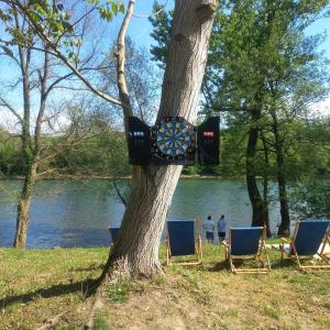 uma árvore com cadeiras e um alvo de dardos numa árvore em Drinsko Srce em Ljubovija