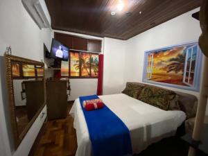 1 dormitorio con 1 cama y TV. en Kitinete Ipanema, en Río de Janeiro