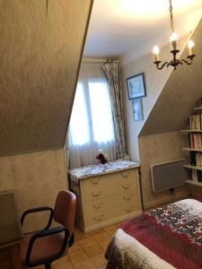 a bedroom with a bed and a dresser and a window at Yufan in La Ville-du-Bois