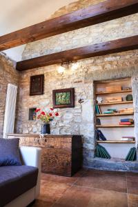 sala de estar con pared de piedra y sofá en Ca'Toni en Bagnone
