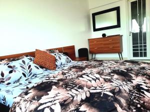- une chambre avec un lit, une commode et un miroir dans l'établissement Appartement African Chic, à Dakar