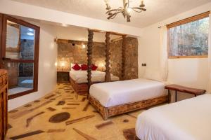 a bedroom with two beds and a bathroom at Dar l'eau Vive in Bine el Ouidane