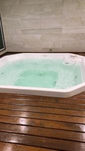 d'une baignoire remplie d'eau verte sur le parquet. dans l'établissement Apartamento temporada em Arraial do Cabo, Le Bon Vivant, à Arraial do Cabo