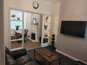 sala de estar con sofá y TV de pantalla plana en 3 Bedroom Entire House en Middlesbrough