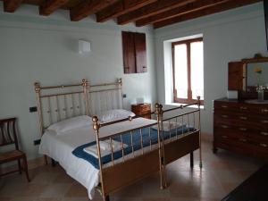 a bedroom with a bed and a dresser and a mirror at Le Camere Della Bice in Negrar