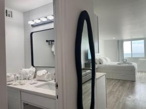 a bathroom with a mirror and a sink and a bed at Top of the Gulf 815 in Panama City Beach