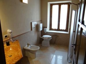 a bathroom with a toilet and a sink and a window at Le Camere Della Bice in Negrar
