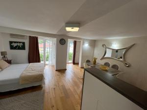 a bedroom with a bed and a sink and a bathroom at Apartments Villa Jovovic in Budva