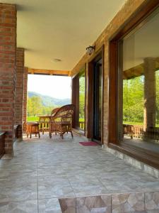 a screened in porch with a bench and windows at Drinsko Srce in Ljubovija