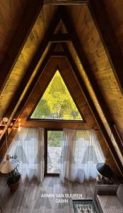 een kamer met een groot raam op een zolder bij Agora Farmhouse in Koman