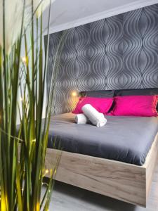 um quarto com uma cama com almofadas cor-de-rosa em Cosy escape em Sfântu Gheorghe