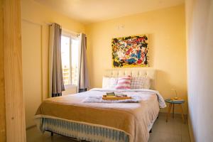 a bedroom with a bed with a painting on the wall at Casa Areal,1 Suíte, 2 Quartos Climatizados, piscina e Estacionamento 2 carros in Pelotas +145 photos