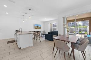 eine Küche und ein Wohnzimmer mit Tisch und Stühlen in der Unterkunft NEW Disney Golf Private Pool Gym Waterpark Resort in Kissimmee