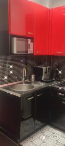 a kitchen with red cabinets and a sink at W Starym Kinie in Ustka