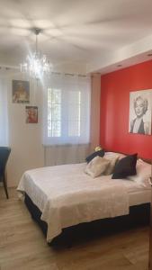 1 dormitorio con 1 cama grande y pared roja en W Starym Kinie, en Ustka
