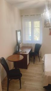 a room with a desk and two chairs and a bed at W Starym Kinie in Ustka