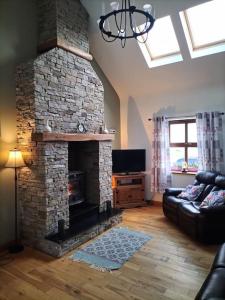 ein Wohnzimmer mit einem Steinkamin und einem Sofa in der Unterkunft Arranmore Cottage in Aphort