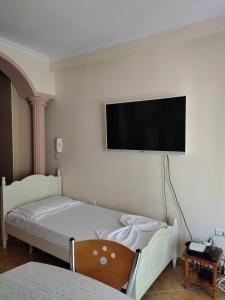 a bedroom with a bed with a flat screen tv on the wall at Apartment in Lungo Mare Vlore in Vlorë