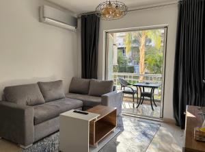 sala de estar con sofá y mesa en Luxury Inn:2BR Amazing Garden View in Madinaty B10, en Madinaty