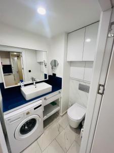 Un baño con lavabo y lavadora. en orbi blu apart otel, en Batumi