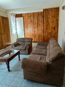 Casa Xelaju Apartments في كويتزالتنانغو: غرفة معيشة مع أريكة وطاولة قهوة