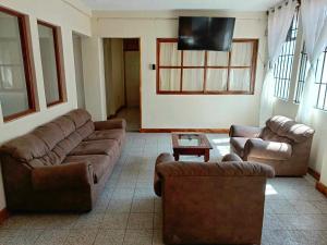 sala de estar con 2 sofás y TV en Casa Xelaju Apartments, en Quetzaltenango