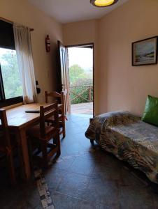 1 dormitorio con escritorio, 1 cama y 1 mesa en Casas Altas VGB en Villa General Belgrano