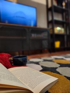 un livre ouvert assis sur une table avec une télévision dans l'établissement Ca' di Rosy, à Ivrea