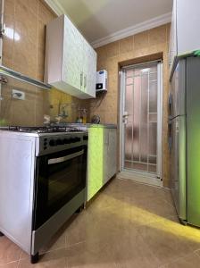 eine Küche mit einem Herd und einem Kühlschrank in der Unterkunft Luxury Inn:2BR Amazing Garden View in Madinaty B10 in Madinaty