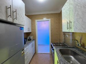 cocina con fregadero y puerta azul en Luxury Inn:2BR Amazing Garden View in Madinaty B10, en Madinaty