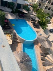 a swimming pool with umbrellas and chairs and a swimming pool at Villa Salena with pool Slatine in Slatine