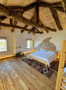 a bedroom with a bed in a room with wooden ceilings at Guesthouse Vitoria - Mrizi i Zanave in Fishtë