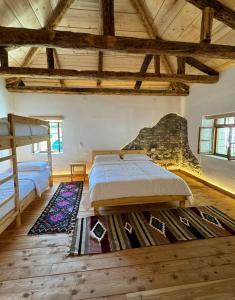 two beds in a room with wooden ceilings at Guesthouse Vitoria - Mrizi i Zanave in Fishtë