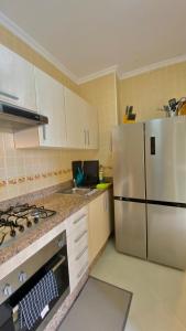 een keuken met een witte koelkast en een wastafel bij 2 Bedrooms 1 Bathrooms-2 Pools&With Direct beach Access in Tanger