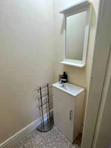 a small bathroom with a sink and a mirror at Elegant hideaway in Manchester